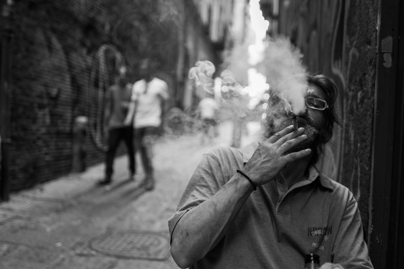 Man setting up a chair in front of his house to smoke a cigar